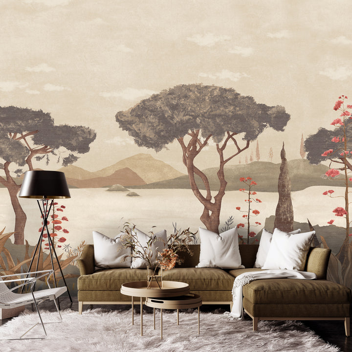A styled living room featuring a large wall mural with a vintage-style landscape painting of trees, mountains, and water. The room is furnished with a brown sectional sofa, white throw pillows, a black floor lamp, and a white shag rug. Scenic Faux Grasscloth Mural - 8294 45 by District Home