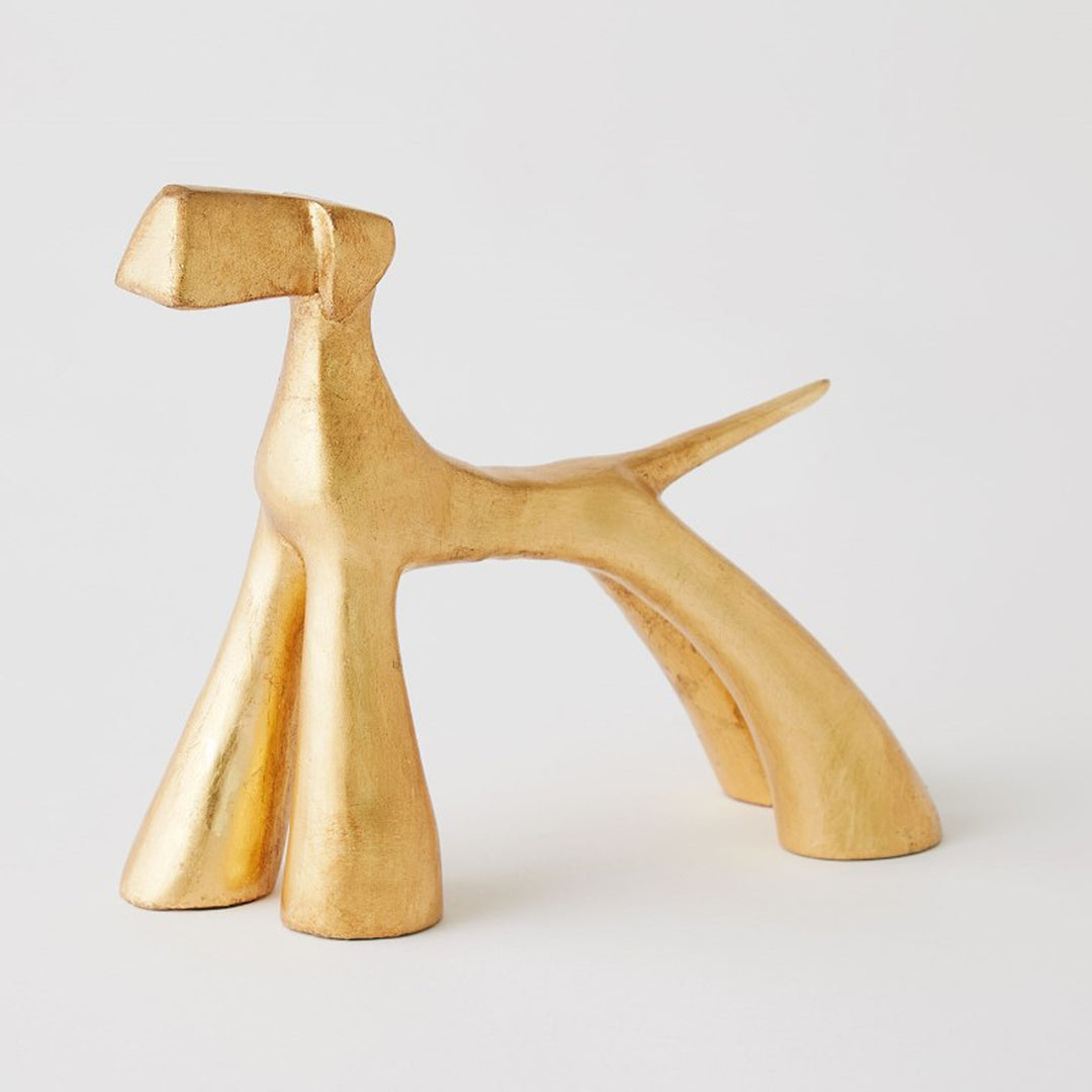 Gold abstract sculpture on a light gray background. Gold Leaf Sculpture Doggo G District Home