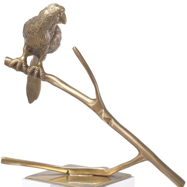 Two gold parrot sculptures on branches with clear bases on a white background. Decorative Sculpture Tweet by District Home