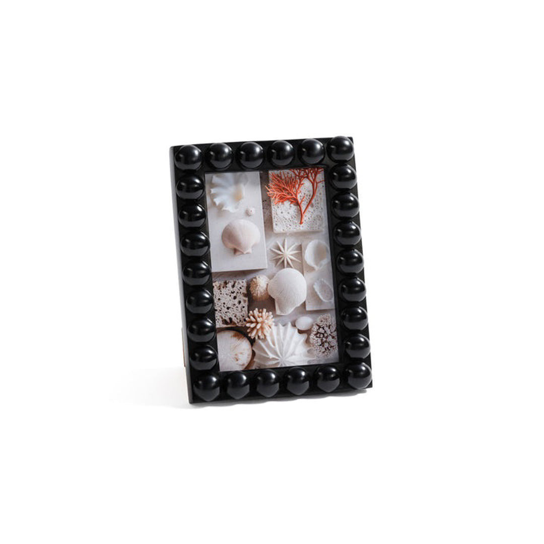 Black beaded photo frame with a collage of seashells and coral on a white background. Photo Frame Viori by District Home