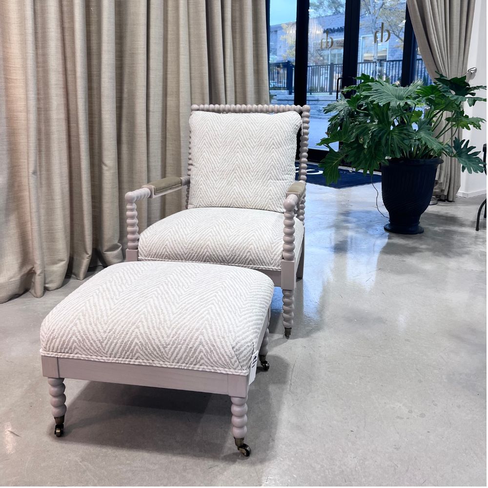 Gray armchair with textured cushion against a neutral curtain background. Keystone Accent Chair by District Home