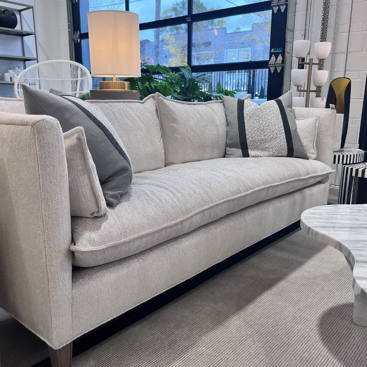 Gray sofa with decorative pillows in a living room setting. Cirrus Sofa by District Home