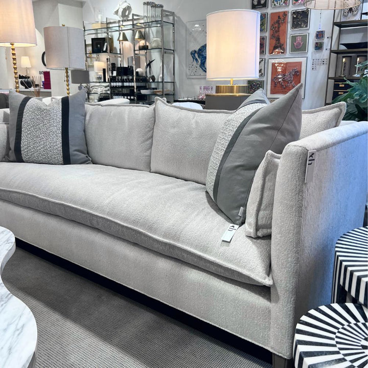 Gray sofa with decorative pillows in a living room setting. Cirrus Sofa by District Home